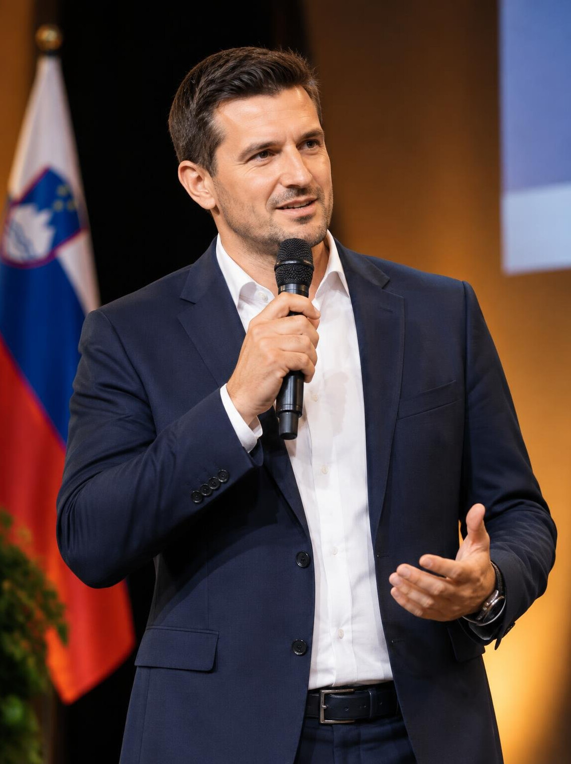 Man speaking confidently into a microphone on stage